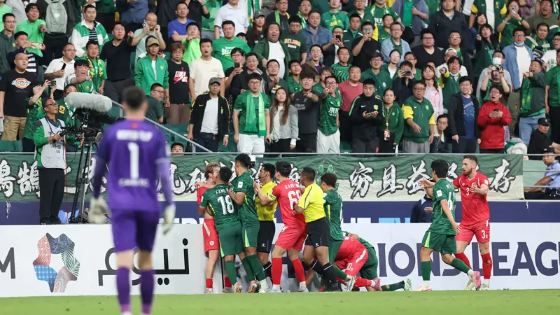 中国とベトナムのサッカー選手が乱闘。, AFCチャンピオンズリーグの試合中に混乱が発生。, 北京国安対ベトナム・ハノイ戦の終盤、乱闘が勃発した。, 両チームの選手が入り乱れての大乱闘。, 時間を無駄にしていた事から口論となり、さらには乱闘へと発展した。, 激しい殴打で状況は緊迫した。, 審判は落ち着きを取り戻そうと奮闘した。, 試合は6分以上中断された。, スタンドから観客がピッチにボトルを投げ入れて抗議した。, 看板の上に倒れる選手もいた。, 意外なことに、審判は誰も退場させなかった。, 緊迫したこの試合は2-2で終了した。