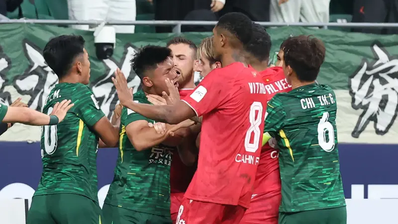 中国とベトナムのサッカー選手が乱闘。, AFCチャンピオンズリーグの試合中に混乱が発生。, 北京国安対ベトナム・ハノイ戦の終盤、乱闘が勃発した。, 両チームの選手が入り乱れての大乱闘。, 時間を無駄にしていた事から口論となり、さらには乱闘へと発展した。, 激しい殴打で状況は緊迫した。, 審判は落ち着きを取り戻そうと奮闘した。, 試合は6分以上中断された。, スタンドから観客がピッチにボトルを投げ入れて抗議した。, 看板の上に倒れる選手もいた。, 意外なことに、審判は誰も退場させなかった。, 緊迫したこの試合は2-2で終了した。