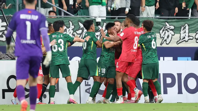 中国とベトナムのサッカー選手が乱闘。, AFCチャンピオンズリーグの試合中に混乱が発生。, 北京国安対ベトナム・ハノイ戦の終盤、乱闘が勃発した。, 両チームの選手が入り乱れての大乱闘。, 時間を無駄にしていた事から口論となり、さらには乱闘へと発展した。, 激しい殴打で状況は緊迫した。, 審判は落ち着きを取り戻そうと奮闘した。, 試合は6分以上中断された。, スタンドから観客がピッチにボトルを投げ入れて抗議した。, 看板の上に倒れる選手もいた。, 意外なことに、審判は誰も退場させなかった。, 緊迫したこの試合は2-2で終了した。