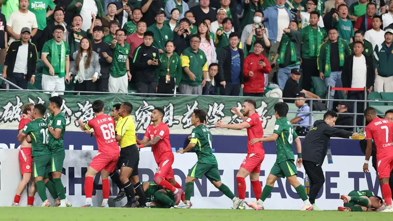 中国とベトナムのサッカー選手が乱闘。, AFCチャンピオンズリーグの試合中に混乱が発生。, 北京国安対ベトナム・ハノイ戦の終盤、乱闘が勃発した。, 両チームの選手が入り乱れての大乱闘。, 時間を無駄にしていた事から口論となり、さらには乱闘へと発展した。, 激しい殴打で状況は緊迫した。, 審判は落ち着きを取り戻そうと奮闘した。, 試合は6分以上中断された。, スタンドから観客がピッチにボトルを投げ入れて抗議した。, 看板の上に倒れる選手もいた。, 意外なことに、審判は誰も退場させなかった。, 緊迫したこの試合は2-2で終了した。