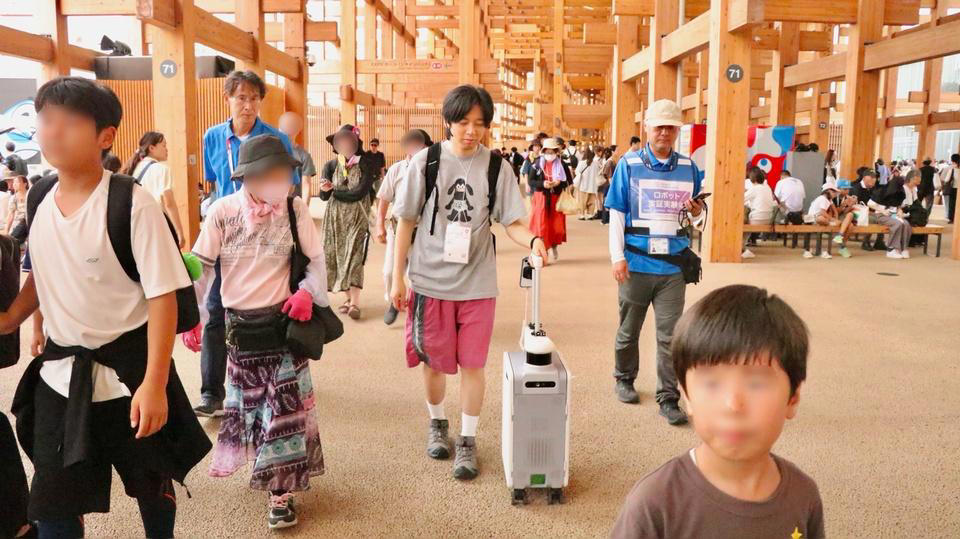 AIスーツケースが、広くて混んでる万博の移動を支える？, 握るだけで動く、離すだけで止まる, 地図データとLiDARセンサーで、リアルタイムに向かうべき道を判断, 移動補助だけじゃない、音声入力にも対応, 人混みでもちゃんと頼れるパートナー, 目をつぶって味わった安心感と万博の"意義"