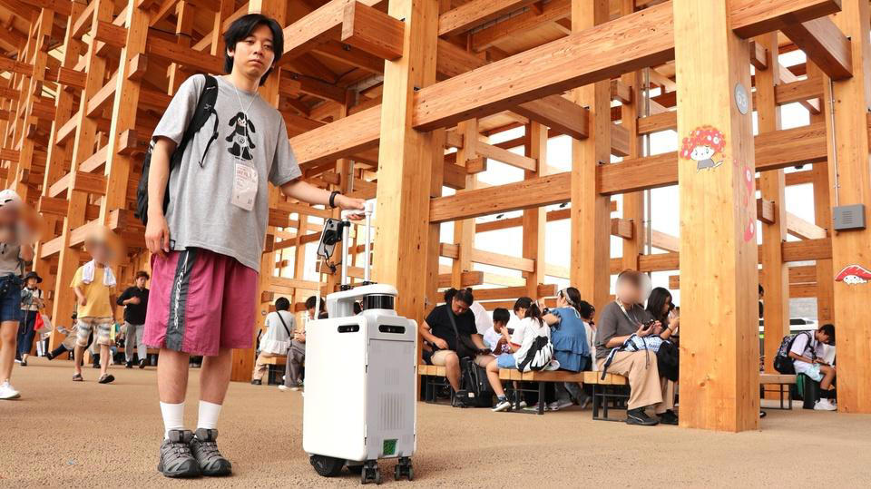 AIスーツケースが、広くて混んでる万博の移動を支える？, 握るだけで動く、離すだけで止まる, 地図データとLiDARセンサーで、リアルタイムに向かうべき道を判断, 移動補助だけじゃない、音声入力にも対応, 人混みでもちゃんと頼れるパートナー, 目をつぶって味わった安心感と万博の"意義"