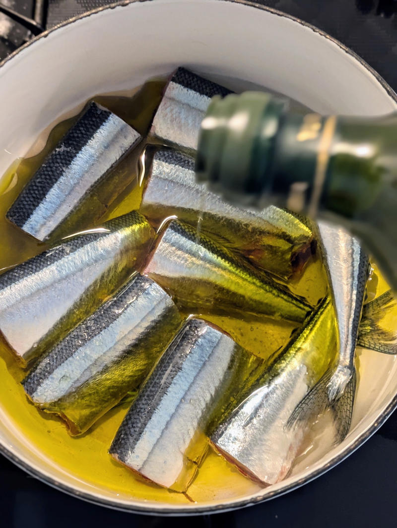 秋刀魚と身近な材料で作れるコンフィ, 鍋にオーブンペーパーを敷いて、焦げ防止, オーブンペーパーで落とし蓋をして低温で煮る, オイルごと密閉で1週間保存可能, 盛りつけるだけで一品完成, 夜のワインのお供に！秋刀魚コンフィでバゲットサンド, 秋刀魚コンフィパスタで、おとなの夜ごはん