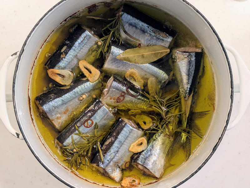 秋刀魚と身近な材料で作れるコンフィ, 鍋にオーブンペーパーを敷いて、焦げ防止, オーブンペーパーで落とし蓋をして低温で煮る, オイルごと密閉で1週間保存可能, 盛りつけるだけで一品完成, 夜のワインのお供に！秋刀魚コンフィでバゲットサンド, 秋刀魚コンフィパスタで、おとなの夜ごはん