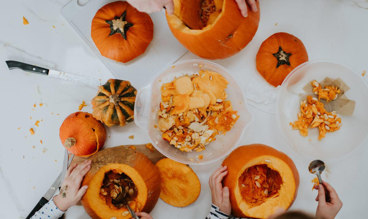 Step 1. Start with the right pumpkin. , Step 2. Begin cutting from the bottom, not the top. , Step 4. Scoop out all the pulp (and then some). , Step 5. Sketch out the design on paper first., Step 6. Hold the pumpkin in your lap. , Step 7. Start with simple rough cuts. , Step 8. Use scraps creatively., Step 9. Keep your pumpkin fresh. , Step 10. Light it up. , Step 11. Create a chimney. , Step 12. Sprinkle cinnamon inside the lid. 