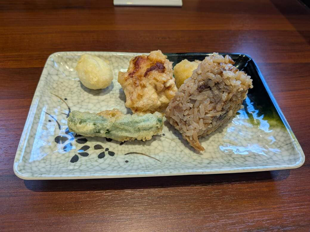 猫も杓子も体験…やたら「体験」を推す外食企業, 新業態1号店は堅実に郊外ロードサイド, オープンから半月経過も行列ができる人気ぶり, 注文はタブレット、上げ膳・下げ膳まですべてお客がやる, 1000円前後で食べ放題付きはお得, 「豚肉つけ汁うどん」1089円はこんな感じ, 従来のうどんチェーンは注文に高度な意思決定が求められる？, 意思決定が負担、でも失敗したくない…現代人のニーズに合ううどん店