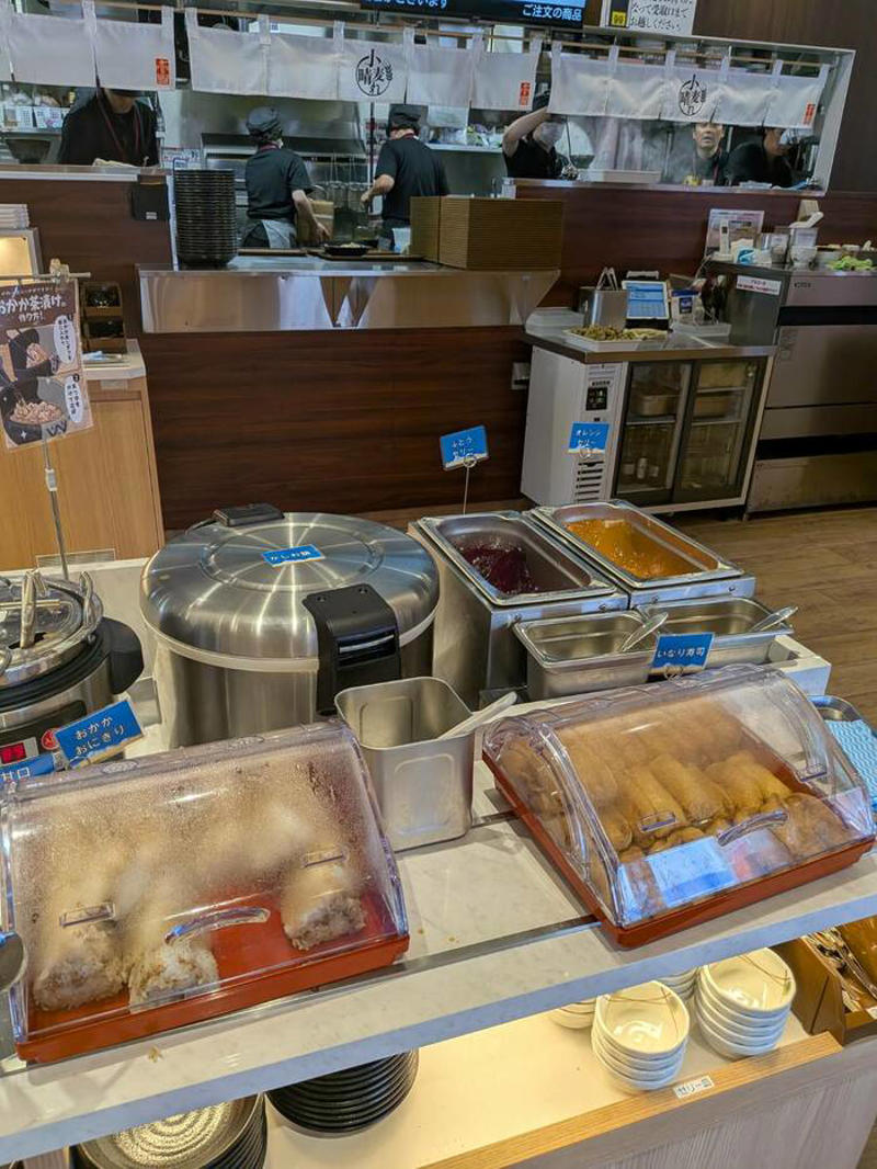 猫も杓子も体験…やたら「体験」を推す外食企業, 新業態1号店は堅実に郊外ロードサイド, オープンから半月経過も行列ができる人気ぶり, 注文はタブレット、上げ膳・下げ膳まですべてお客がやる, 1000円前後で食べ放題付きはお得, 「豚肉つけ汁うどん」1089円はこんな感じ, 従来のうどんチェーンは注文に高度な意思決定が求められる？, 意思決定が負担、でも失敗したくない…現代人のニーズに合ううどん店