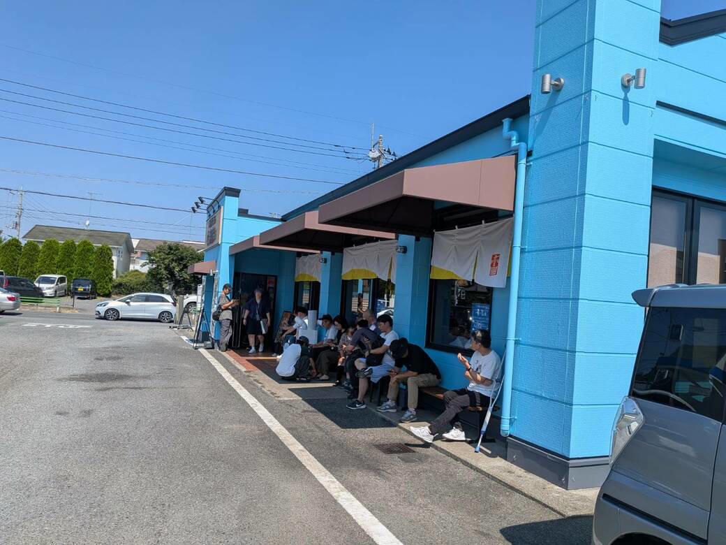 猫も杓子も体験…やたら「体験」を推す外食企業, 新業態1号店は堅実に郊外ロードサイド, オープンから半月経過も行列ができる人気ぶり, 注文はタブレット、上げ膳・下げ膳まですべてお客がやる, 1000円前後で食べ放題付きはお得, 「豚肉つけ汁うどん」1089円はこんな感じ, 従来のうどんチェーンは注文に高度な意思決定が求められる？, 意思決定が負担、でも失敗したくない…現代人のニーズに合ううどん店