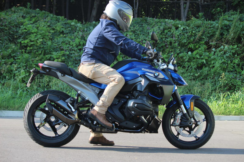 ストリートでの使い勝手の良さと軽快なハンドリング, 初のロードスターとして登場したR100R, 4バルブ化され進化した1100と850のロードスター, R1300Rは前モデルのR1250Rとどう変わったのか？, デザイン：直線基調のシャープな雰囲気に, 前モデルのR1250Rもまだまだ健在のデザインと性能, デザイン：直線基調のシャープな雰囲気に, シャーシ：新設計のフレームで剛性バランスを最適化, エンジン：パワー＆トルクが大幅アップ, サスペンション：オプションでスプリングレートを自動調整するDSAを設定, 電子制御：ライダーの疲労を軽減し、走りに集中できる機能を満載, 快適装備：タイヤ空気圧センサーが標準で搭載, リアシートにはリア専用のヒータースイッチを設置, シート高：前モデルより足着き改善！, 燃料タンク容量：容量は1L減ったが、ポジションの自由度はアップ, 今回はASAに試乗した！, ASA仕様はクラッチレバーを装備しない, あふれ出るライディングプレジャー, 乗る人を選ばないオールラウンドプレーヤー (1/2), 乗る人を選ばないオールラウンドプレーヤー (2/2), 乗る人を選ばないオールラウンドプレーヤー, コストパフォーマンスもかなり高い, シートは薄めだが、長時間乗ってもあまりお尻は痛くならなかった, シャープなデザインのLEDを多用し、すっきりとしたテールランプ周り, 横から見るとラジエーターのファンがむき出しで、ここは機械的な格好良さを感じるポイント