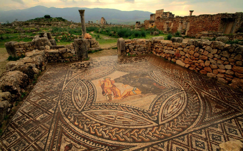 50. Tower of Hercules, Spain, 49. Felix Romuliana, Serbia, 48. Capidava, Romania, 47. Garni Temple, Armenia, 46. The Walls of Lugo, Spain, 45. Temple of Évora, Portugal, 44. The Basilica Cistern, Turkey, 43. Theatre of Philippopolis, Bulgaria, 42. Butrint, Albania, 41. Paphos Archaeological Park, Cyprus, 40. The Antonine Wall, UK, 39. The Temple of Jupiter, Damascus, Syria, 38. The Theatre of Vienne, France, 37. Kom el-Dikka, Egypt, 36. Palmyra, Syria, 35. Ostia Antica, Italy, 34. Arena of Nîmes, France, 33. Arles Amphitheatre, France, 32. Roman Carthage, Tunisia, 31. Antium, Italy, 30. Sabratha, Libya, 29. Djémila, Algeria, 28. Verona Arena, Italy, 27. Amphitheatre of El Jem, Tunisia, 26. Aqueduct of Segovia, Spain, 25. Pula Amphitheatre, Croatia, 24. Villa Adriana, Italy, 23. Tarraco, Spain, 22. Herculaneum, Italy, 21. Jerash, Jordan, 20. Aula Palatina, Germany, 19. Volubilis, Morocco, 18. Theatre of Aspendos, Turkey, 17. Theatre of Bosra, Syria, 16. Temple of Bacchus at Baalbek, Lebanon, 15. Hadrian’s Library and The Odeon of Herodes Atticus, Greece, 14. Caesarea Maritima, Israel, 13. Leptis Magna, Libya, 12. Timgad, Algeria, 11. The Roman Baths, UK, 10. Pont du Gard, France, 9. The Baths of Caracalla/The Circus Maximus, Italy, 8. Augusta Emerita, Spain, 7. The Library of Celsus, Turkey, 6. Theatre of Orange, France, 5. The Pantheon, Italy, 4. The Palace of Diocletian, Croatia, 3. Hadrian’s Wall, UK, 2. The Roman Forum/The Colosseum, Italy, 1. Pompeii, Italy