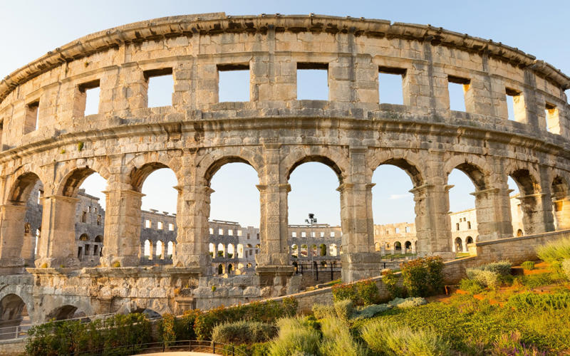 50. Tower of Hercules, Spain, 49. Felix Romuliana, Serbia, 48. Capidava, Romania, 47. Garni Temple, Armenia, 46. The Walls of Lugo, Spain, 45. Temple of Évora, Portugal, 44. The Basilica Cistern, Turkey, 43. Theatre of Philippopolis, Bulgaria, 42. Butrint, Albania, 41. Paphos Archaeological Park, Cyprus, 40. The Antonine Wall, UK, 39. The Temple of Jupiter, Damascus, Syria, 38. The Theatre of Vienne, France, 37. Kom el-Dikka, Egypt, 36. Palmyra, Syria, 35. Ostia Antica, Italy, 34. Arena of Nîmes, France, 33. Arles Amphitheatre, France, 32. Roman Carthage, Tunisia, 31. Antium, Italy, 30. Sabratha, Libya, 29. Djémila, Algeria, 28. Verona Arena, Italy, 27. Amphitheatre of El Jem, Tunisia, 26. Aqueduct of Segovia, Spain, 25. Pula Amphitheatre, Croatia, 24. Villa Adriana, Italy, 23. Tarraco, Spain, 22. Herculaneum, Italy, 21. Jerash, Jordan, 20. Aula Palatina, Germany, 19. Volubilis, Morocco, 18. Theatre of Aspendos, Turkey, 17. Theatre of Bosra, Syria, 16. Temple of Bacchus at Baalbek, Lebanon, 15. Hadrian’s Library and The Odeon of Herodes Atticus, Greece, 14. Caesarea Maritima, Israel, 13. Leptis Magna, Libya, 12. Timgad, Algeria, 11. The Roman Baths, UK, 10. Pont du Gard, France, 9. The Baths of Caracalla/The Circus Maximus, Italy, 8. Augusta Emerita, Spain, 7. The Library of Celsus, Turkey, 6. Theatre of Orange, France, 5. The Pantheon, Italy, 4. The Palace of Diocletian, Croatia, 3. Hadrian’s Wall, UK, 2. The Roman Forum/The Colosseum, Italy, 1. Pompeii, Italy