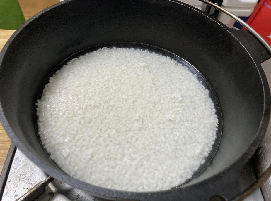 キャンプでご飯を炊く前に！まずは基本の道具を知ろう, 炊飯に必要な「基本セット」, 道具のメリット・デメリット, キャンプで失敗せずに美味しくご飯を炊くコツ, 1.米と水の「計量」は正確に行う, 2.「吸水」を最低30分（冬場は1時間）は行う, 3.火加減は「沸騰するまで中火 → 沸騰したら弱火」, 4.炊飯中は「絶対に蓋を開けない」, 5.火から下ろしたら「必ず10分以上蒸らす」, 【道具別】炊き方ガイド｜メスティン・飯ごう・鍋・ライスクッカー・ダッチオーブン, 鍋（クッカー）は重しを使うのがポイント, 飯ごうは蓋で軽量もできるのがポイント, メスティンは火加減がポイント, ライスクッカーは機能をフル活用するのがポイント, ダッチオーブンは蓋の上に炭を置くのがポイント, もっと美味しく！キャンプで食べたい絶品ご飯レシピ, 缶詰ひとつで味が決まる！超簡単「炊き込みご飯」, 「お焦げ」も「残りご飯」もごちそうに！翌朝活用レシピ, 美味しいご飯が、キャンプをもっと楽しくする