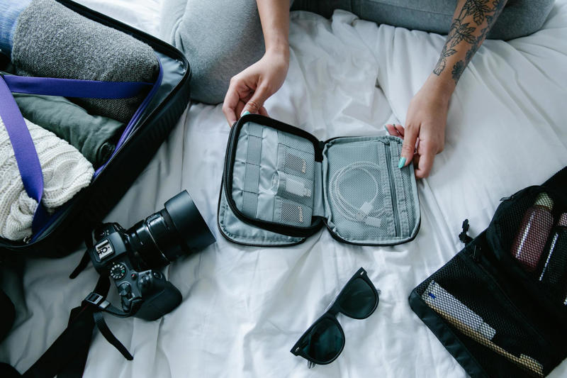 1. Universal travel adapter , 2. Compact external battery (power bank) , 3. Cable organizer and tech accessories , 4. Hanging toilet bag , 5. Travel pouch for documents and passport , 6. Noise-reducing headphones or earphones , 7. Foldable auxiliary bag (lightweight tote or backpack) , 1.Low-end inflatable neck pillow , 2. Suspended aircraft footrest , 3. Mini portable washing machine , 4. Ultra-visible ticket-covering belt , 5. Personal portable air purifier , 6. Bamboo travel cutlery in hard case , 7. Electronic suitcase scale