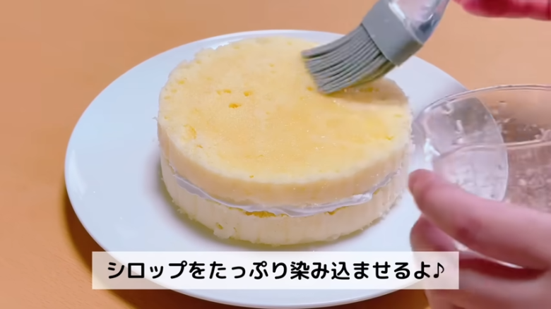 ①.   クッキングシートをタッパーの側面に合わせてカット, ②.   クッキングシートをタッパーの底面に合わせてカット, ①.　耐熱ボウルにスーパーカップを入れ電子レンジで溶かす, ②.　①に砂糖、油を加えて混ぜる, ③.　②にホットケーキミックスを加えて混ぜる, ④.　③の生地をタッパーに流し入れ、何回かトントン落としてふんわりラップをかける, ⑤.　電子レンジで加熱する, ⑥.　キッチンペーパーをかぶせて網で冷ます, ⑦.　クッキングシートを外してスポンジを3枚にカットする, ⑧.　シロップを染み込ませながらデコレーションする, ⑨.　最後に1時間ほど冷蔵庫で冷やして完成
