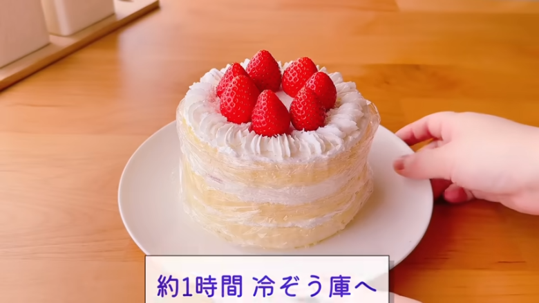①.   クッキングシートをタッパーの側面に合わせてカット, ②.   クッキングシートをタッパーの底面に合わせてカット, ①.　耐熱ボウルにスーパーカップを入れ電子レンジで溶かす, ②.　①に砂糖、油を加えて混ぜる, ③.　②にホットケーキミックスを加えて混ぜる, ④.　③の生地をタッパーに流し入れ、何回かトントン落としてふんわりラップをかける, ⑤.　電子レンジで加熱する, ⑥.　キッチンペーパーをかぶせて網で冷ます, ⑦.　クッキングシートを外してスポンジを3枚にカットする, ⑧.　シロップを染み込ませながらデコレーションする, ⑨.　最後に1時間ほど冷蔵庫で冷やして完成