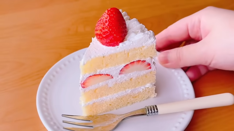 ①.   クッキングシートをタッパーの側面に合わせてカット, ②.   クッキングシートをタッパーの底面に合わせてカット, ①.　耐熱ボウルにスーパーカップを入れ電子レンジで溶かす, ②.　①に砂糖、油を加えて混ぜる, ③.　②にホットケーキミックスを加えて混ぜる, ④.　③の生地をタッパーに流し入れ、何回かトントン落としてふんわりラップをかける, ⑤.　電子レンジで加熱する, ⑥.　キッチンペーパーをかぶせて網で冷ます, ⑦.　クッキングシートを外してスポンジを3枚にカットする, ⑧.　シロップを染み込ませながらデコレーションする, ⑨.　最後に1時間ほど冷蔵庫で冷やして完成