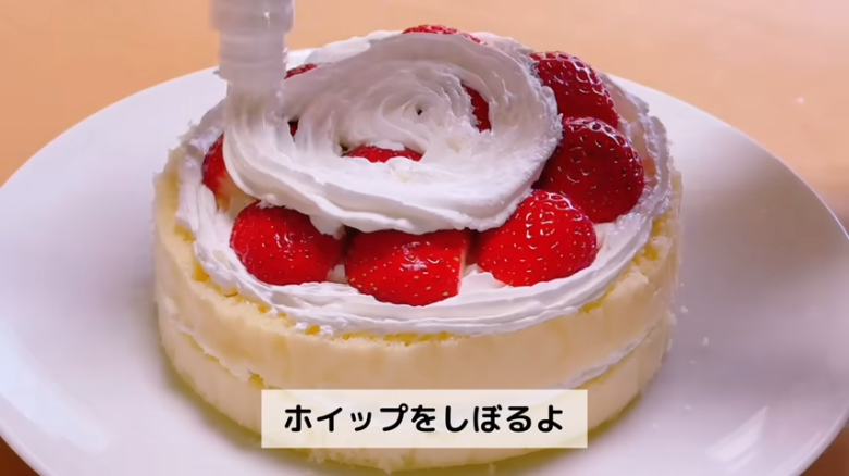 ①.   クッキングシートをタッパーの側面に合わせてカット, ②.   クッキングシートをタッパーの底面に合わせてカット, ①.　耐熱ボウルにスーパーカップを入れ電子レンジで溶かす, ②.　①に砂糖、油を加えて混ぜる, ③.　②にホットケーキミックスを加えて混ぜる, ④.　③の生地をタッパーに流し入れ、何回かトントン落としてふんわりラップをかける, ⑤.　電子レンジで加熱する, ⑥.　キッチンペーパーをかぶせて網で冷ます, ⑦.　クッキングシートを外してスポンジを3枚にカットする, ⑧.　シロップを染み込ませながらデコレーションする, ⑨.　最後に1時間ほど冷蔵庫で冷やして完成