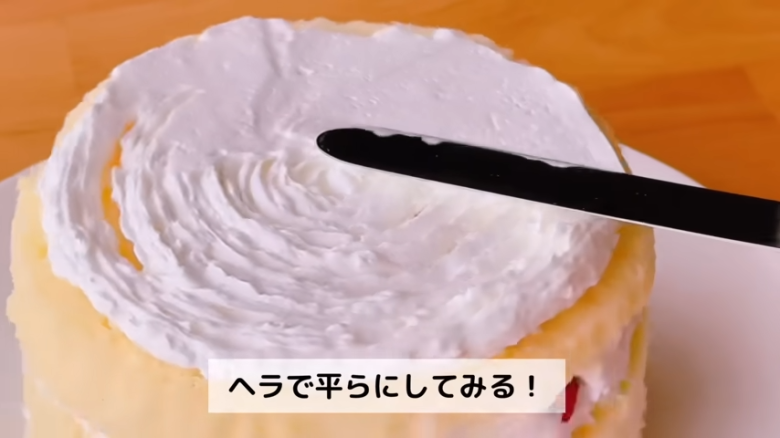 ①.   クッキングシートをタッパーの側面に合わせてカット, ②.   クッキングシートをタッパーの底面に合わせてカット, ①.　耐熱ボウルにスーパーカップを入れ電子レンジで溶かす, ②.　①に砂糖、油を加えて混ぜる, ③.　②にホットケーキミックスを加えて混ぜる, ④.　③の生地をタッパーに流し入れ、何回かトントン落としてふんわりラップをかける, ⑤.　電子レンジで加熱する, ⑥.　キッチンペーパーをかぶせて網で冷ます, ⑦.　クッキングシートを外してスポンジを3枚にカットする, ⑧.　シロップを染み込ませながらデコレーションする, ⑨.　最後に1時間ほど冷蔵庫で冷やして完成