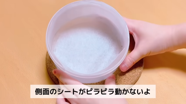 ①.   クッキングシートをタッパーの側面に合わせてカット, ②.   クッキングシートをタッパーの底面に合わせてカット, ①.　耐熱ボウルにスーパーカップを入れ電子レンジで溶かす, ②.　①に砂糖、油を加えて混ぜる, ③.　②にホットケーキミックスを加えて混ぜる, ④.　③の生地をタッパーに流し入れ、何回かトントン落としてふんわりラップをかける, ⑤.　電子レンジで加熱する, ⑥.　キッチンペーパーをかぶせて網で冷ます, ⑦.　クッキングシートを外してスポンジを3枚にカットする, ⑧.　シロップを染み込ませながらデコレーションする, ⑨.　最後に1時間ほど冷蔵庫で冷やして完成