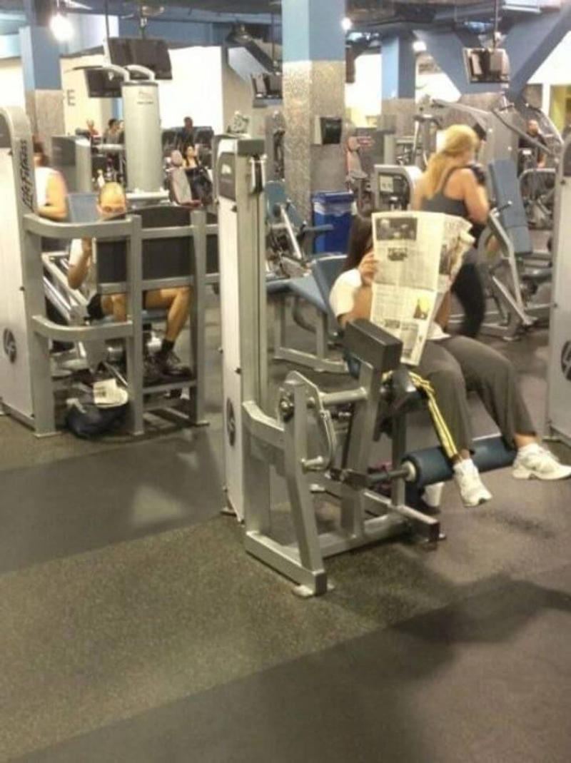 Reading the Newspaper on a Gym Machine, Man Using Gym Equipment Wrong, Guy Dressed Like Kill Bill at the Gym, Man Using an Exercise Ball in a Weird Way, Man Completely Confused by Gym Equipment, Man Reading the Newspaper, Old Lady Using Gym Machine Wrong, Guy Screaming While Exercising, Man Standing on Stacked Weights, Guy Bending Way Too Much While Lifting Weights, Woman Striking a Very Strange Pose, Weights on Her Back While on Her Phone, Woman Lying Down at the Gym Using Her Phone, Two-Wheel Scooter on a Treadmill, Woman Lying Down, Ignoring the Machine, Guy Carrying a Giant iPad on His Back, Full Cyclist Mode, Guy Eating at the Gym