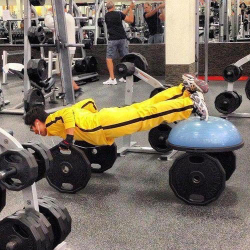 Reading the Newspaper on a Gym Machine, Man Using Gym Equipment Wrong, Guy Dressed Like Kill Bill at the Gym, Man Using an Exercise Ball in a Weird Way, Man Completely Confused by Gym Equipment, Man Reading the Newspaper, Old Lady Using Gym Machine Wrong, Guy Screaming While Exercising, Man Standing on Stacked Weights, Guy Bending Way Too Much While Lifting Weights, Woman Striking a Very Strange Pose, Weights on Her Back While on Her Phone, Woman Lying Down at the Gym Using Her Phone, Two-Wheel Scooter on a Treadmill, Woman Lying Down, Ignoring the Machine, Guy Carrying a Giant iPad on His Back, Full Cyclist Mode, Guy Eating at the Gym