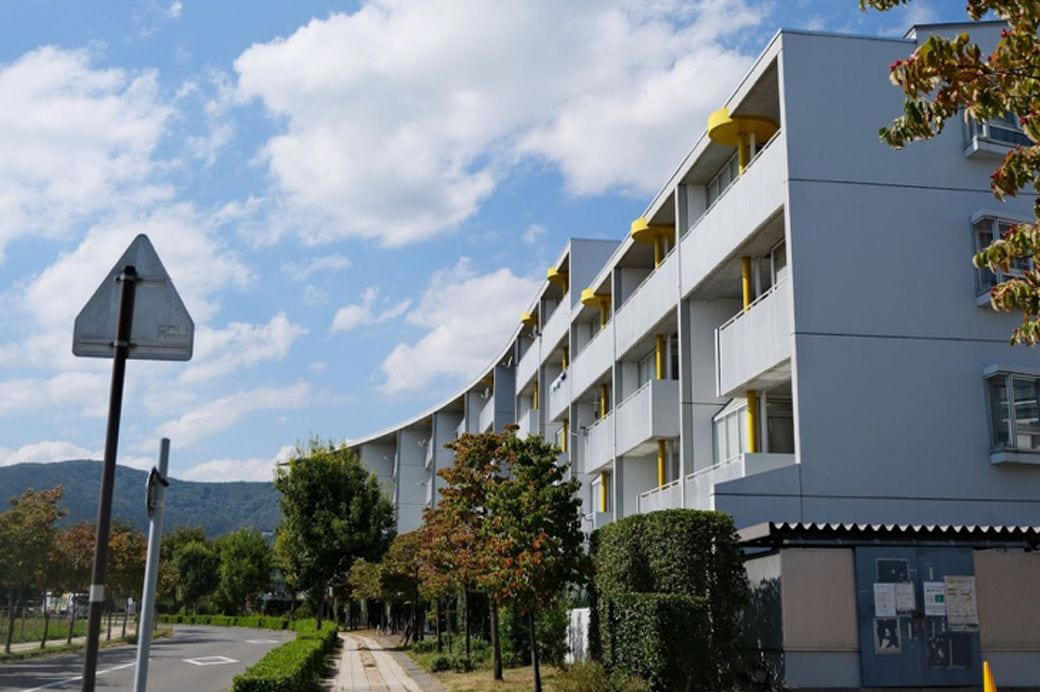 個性的な住棟に水路が走る「フシギなまち」, 30年前、農地に誕生したニュータウン, どこに「オリンピック村」をつくるのか？, 設計者はなんと28名「異例の体制」, 複雑な調整を経て生まれた「新しいまち」, ニュータウンも住戸も「バリアフリー」, ベランダも広々とした、気持ちのいい団地