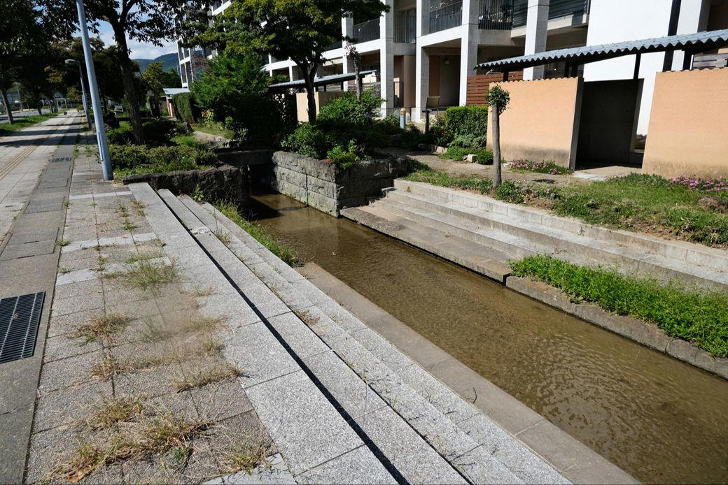 個性的な住棟に水路が走る「フシギなまち」, 30年前、農地に誕生したニュータウン, どこに「オリンピック村」をつくるのか？, 設計者はなんと28名「異例の体制」, 複雑な調整を経て生まれた「新しいまち」, ニュータウンも住戸も「バリアフリー」, ベランダも広々とした、気持ちのいい団地