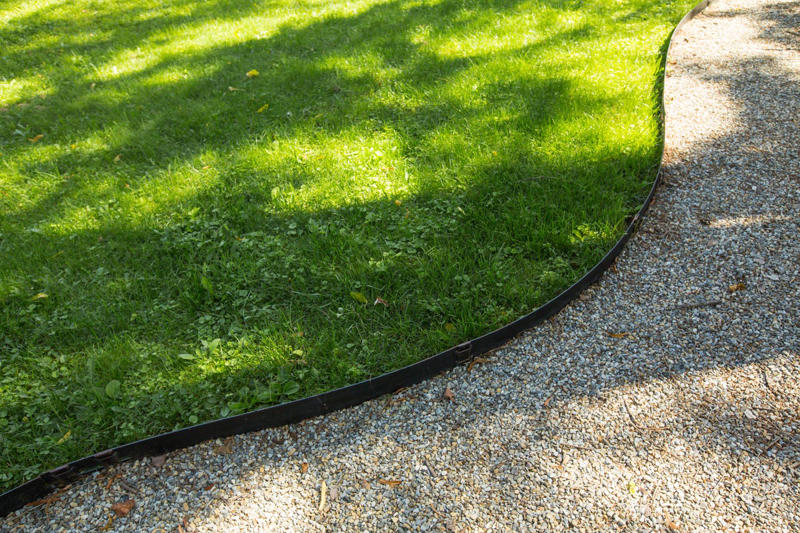 Why Edging Matters, Types of Edging, Free: Hand Edging, Almost Free: Glass Bottle Edging , Practically Free: Natural Log Edging, Inexpensive: Plastic Edging, Inexpensive: Woven Willow Edging, Inexpensive: Cedar Edging, Inexpensive: Landscape Timber Edging, Inexpensive: Bamboo Edging, Inexpensive: Pound-In Plastic Edging, Inexpensive: Metal Edging, Less Expensive: Scalloped Terracotta Edging, Less Expensive: Brick Edging, Less Expensive: Eucalyptus Wood Border Edging, Less Expensive: Grass and Shrub Edging, Less Expensive: Mixed Plant Edging,  Less Expensive: Gravel Edging, Less Expensive: Recycled Rubber Edging, Less Expensive: Stone and Gravel Edging, Less Expensive: Stone Pillar Edging , Moderately Expensive: Tidy Living Hedge Edging, Moderately Expensive: Weathering Steel Edging, Moderately Expensive: Paver Stone Edging, Moderately Expensive: Flagstone Edging, Expensive: Concrete Wall Edging, Expensive: Brick Wall Edging, Expensive: Decorative Fence Edging, Expensive: Raised-Garden Bed Edging, Expensive: Poured Concrete Edging, Various Prices: Natural Rock Edging, Various Prices: Antique Ironwork Border
