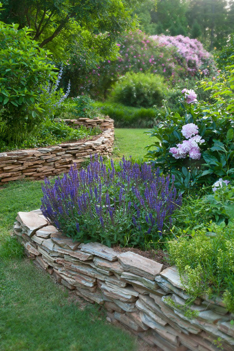 Why Edging Matters, Types of Edging, Free: Hand Edging, Almost Free: Glass Bottle Edging , Practically Free: Natural Log Edging, Inexpensive: Plastic Edging, Inexpensive: Woven Willow Edging, Inexpensive: Cedar Edging, Inexpensive: Landscape Timber Edging, Inexpensive: Bamboo Edging, Inexpensive: Pound-In Plastic Edging, Inexpensive: Metal Edging, Less Expensive: Scalloped Terracotta Edging, Less Expensive: Brick Edging, Less Expensive: Eucalyptus Wood Border Edging, Less Expensive: Grass and Shrub Edging, Less Expensive: Mixed Plant Edging,  Less Expensive: Gravel Edging, Less Expensive: Recycled Rubber Edging, Less Expensive: Stone and Gravel Edging, Less Expensive: Stone Pillar Edging , Moderately Expensive: Tidy Living Hedge Edging, Moderately Expensive: Weathering Steel Edging, Moderately Expensive: Paver Stone Edging, Moderately Expensive: Flagstone Edging, Expensive: Concrete Wall Edging, Expensive: Brick Wall Edging, Expensive: Decorative Fence Edging, Expensive: Raised-Garden Bed Edging, Expensive: Poured Concrete Edging, Various Prices: Natural Rock Edging, Various Prices: Antique Ironwork Border