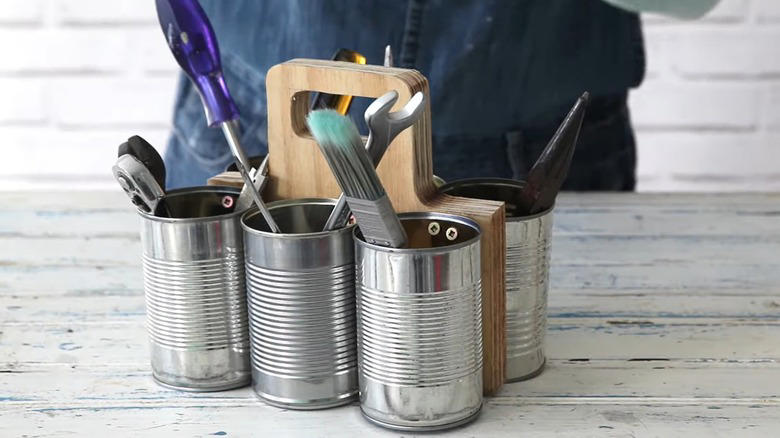 Repurpose a soup can into an adorable planter, Craft metal luminaries from empty soup cans, Transform a metal can into a unique bathroom vase, Make soup cans into chic, vintage-inspired desk organizers, Design a shabby chic carrying caddy from soup containers, Turn a ribbed can into a utensil crock, Decoupage metal cans into labeled pencil holders, Collect cans to make a wind chime, Hang a soup can as a basic bird feeder, Craft farmhouse decor with a smashed soup can, Transform a tin can into a nautical vase for coastal decor, Build a portable tool case out of metal cans, DIY an industrial wine rack from tin cylinders, Create festive tin can streamers