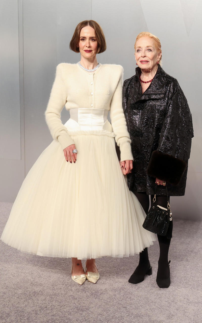 Sarah Paulson and Holland Taylor Oscars 2026, Jane Fonda, Sarah Pidgeon in Calvin Klein, Olivia Rodrigo in Saint Laurent, Naomi Watts in Balenciaga, Monica Lewinsky in Oscar de la Renta, Kim Kardashian in Gucci, Wendi Deng Murdoch and Grace Murdoch, Minnie Driver, Nicole Kidman, Marisa Abela in Revolve, Zoe Saldana in Saint Laurent, Helen Hunt in Stella McCartney, Hailey Bieber in Giorgio Armani, Kaia Gerber in Givenchy, Colman Domingo in Jacquemus, Philippine Leroy-Beaulieu, Sir Mick Jagger and Melanie Hamrick, Jeff Goldblum and Emilie Livingston in ERL Artisanal, Cara Delevingne in Thom Browne, Karlie Kloss in Gucci, Anjelica Huston, Sarah Paulson and Holland Taylor, Leslie Mann, Meg Ryan, Lauren Sanchez Bezos and Jeff Bezos, Tracee Ellis Ross in Marine Serre, Dree Hemingway in Conner Ives, Isla Fisher in Yara Shoemaker, Jessica Alba in Tamara Ralph, Kris Jenner in vintage Valentino, Rachel Sennott in Balenciaga, Dua Lipa and Callum Turner, Kristen Wiig in Monse, Elle and Dakota Fanning, Simone Ashley, Laura Harrier in Gucci, Kendall Jenner in Chanel, Grace Gummer, Mamie Gummer, Louisa Jacobson in Khaite, Suki Waterhouse and Robert Pattinson, Rita Ora in Tamara Ralph, Jessie Buckley in Chanel, Nicole Kidman in Chanel, Rose Byrne in Dior, Teyana Taylor in Chanel, Renate Reinsve in Louis Vuitton, Timothée Chalamet in Givenchy, Kylie Jenner in Schiaparelli, Demi Moore in Gucci, Gwyneth Paltrow in Armani Privé, Michael B. Jordan in Louis Vuitton, Zendaya and Robert Pattinson, Emma Stone in Louis Vuitton, Kate Hudson and Goldie Hawn, Chase Infiniti in Louis Vuitton, Felicity Jones in Prada, Anne Hathaway in Valentino, Odessa A’zion in Valentino, Wunmi Mosaku in Louis Vuitton, Elle Fanning in Givenchy, Kirsten Dunst and Jesse Plemons, Amy Madigan in Dior, Zoe Saldaña in Saint Laurent, Mia Goth in Dior, Paul Mescal and Gracie Abrams, Inga Ibsdotter Lilleaas in Loewe, Mikey Madison in Dior, Rachel McAdams in Alberta Ferretti, Mckenna Grace, Pedro Pascal in Chanel, Barbie Ferreira in GapStudio, Adrien Brody in Gucci, Jacob Elordi in Bottega Veneta, Charithra Chandran in Miss Sohee, EJAE in Dior, Audrey Nuna in Thom Browne, Rei Ami in Rahul Mishra, Huma Abedin and Anna Wintour, Leonardo DiCaprio in Dior, Kate Hawley, Damson Idris in Prada, Sigourney Weaver in Valentino, Alana Haim in Louis Vuitton, Heidi Klum, Hudson Williams in Balenciaga, Alicia Silverstone, Channing Tatum in Versace, Kathy Bates, Chloe Zhao, Joel Edgerton, Misty Copeland in David Koma, Maya Rudolph in Chanel, Ava DuVernay in Louis Vuitton, Anna Wintour, Benicio Del Toro in Giorgio Armani, Usher in Giuliva Heritage, Melissa McCarthy, Jack O’Connell in Dunhill, Lola Kirke in Simone Rocha, Fran Drescher in Ami, Jason Bateman in Dunhill, Ariana Greenblatt in John Galliano, Stellan Skarsgård, Kristen Wiig in Elie Saab, Jacobi Jupe, Kieran Culkin in Paul Smith, Nick Jonas and Priyanka Chopra Jonas, Wagner Moura in Zegna, Conan O’Brien, Vicky Krieps in Bottega Veneta, Ethan Hawke, Shaboozey in Campillo, Spike Lee, Joe Alwyn in Valentino, Kevin O’Leary, Ryan Destiny in Ami, Javier Bardem, Mark Strong in Giorgio Armani, Felix Kammerer in Saint Laurent, Ginnifer Goodwin in Monse, Susie and Nick Cave, Amelia Dimoldenberg in Ralph Lauren, Manu Rios in Saint Laurent