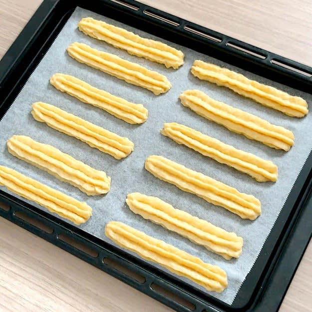 カリもち豆腐チュロス, 作り方：① 絹豆腐をなめらかになるまで混ぜ、, ② クッキングシートに①を絞り、表面に油（分量外、適量）を塗る。, ③ 180℃に予熱したオーブンで15分焼いたら、完成！, 焼き上がりを見て「これ、本当に揚げてないの？」と思いました。, ✔️失敗しないポイント
