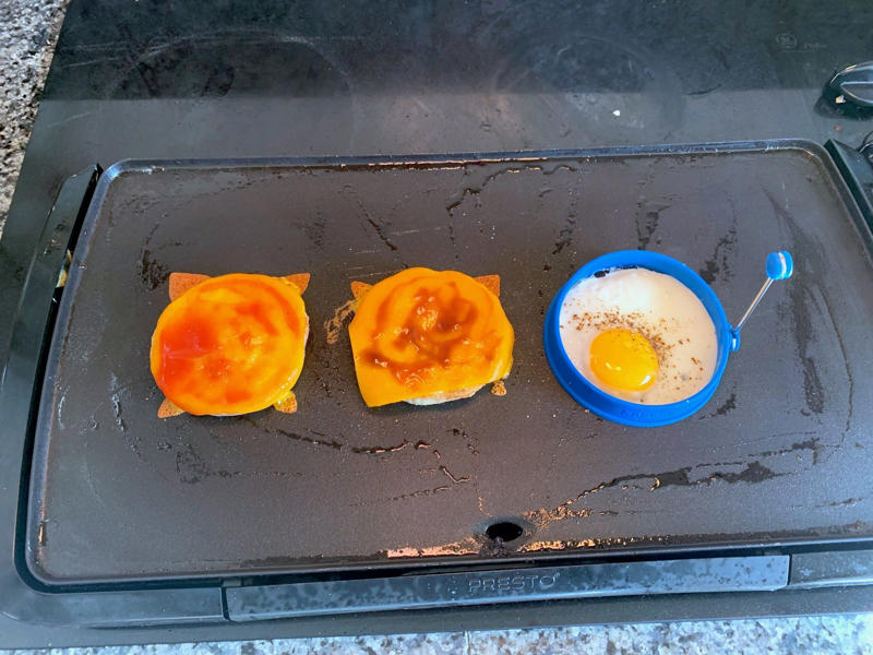 Marchand's bacon and egg muffin requires just a few main ingredients., To begin, I first cooked my bacon., As the bacon started cooking, I prepped my English muffins., Then it was time to start building the sandwich., Once the cheddar slices had softened, it was time for some saucin'., Then I added the bacon slices., I plopped my egg right on top of the bacon.