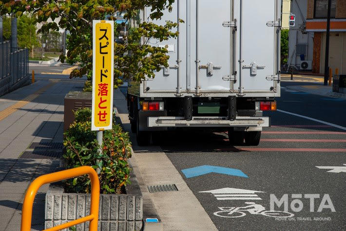 青いレーンへの駐車は場所によって違法！ 2種類の区分の違い, 駐車が違反となりやすい「自転車専用通行帯」, 「自転車ナビマーク・ナビライン」でも違反になる可能性大, 自転車レーンでの駐車違反、反則金はいくら？ 取り締まりの実態, 反則金と違反点数｜駐車違反の罰則, 駐車と停車の違い, 合法・違法を問わず危険！ 自転車レーンへの駐車が引き起こす事故リスク, 駐車車両が自転車を車道へ押し出す構造的な危険性, 予測不能な飛び出しとドアリングで加害者になるおそれ, 自転車レーン付近での安全な運転方法, 自転車の後続を走る場合：1〜1.5m以上の側方間隔を確保する, やむを得ず停車する際の安全対策：後ろを振り向く開け方「ダッチリーチ」と早めのハザード点灯, まとめ：青いレーンでの駐車回避と自転車の急な膨らみへの備えが安全の鍵, おさらい：青いレーンに関する重要ポイント