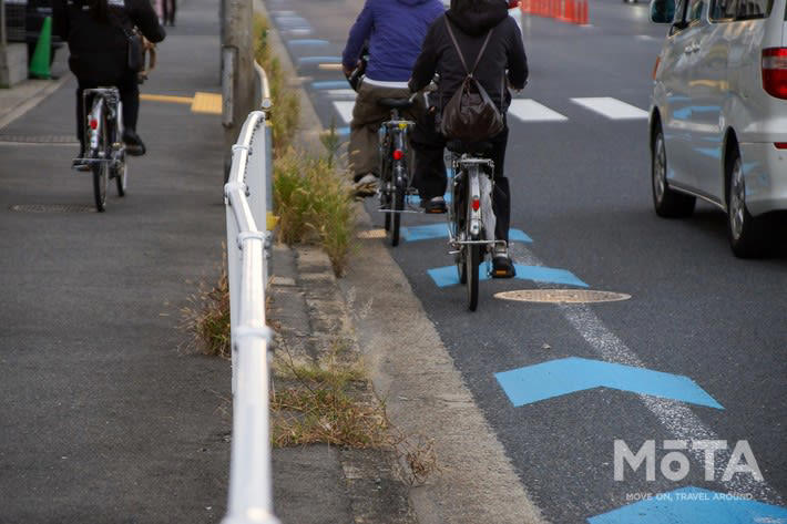 青いレーンへの駐車は場所によって違法！ 2種類の区分の違い, 駐車が違反となりやすい「自転車専用通行帯」, 「自転車ナビマーク・ナビライン」でも違反になる可能性大, 自転車レーンでの駐車違反、反則金はいくら？ 取り締まりの実態, 反則金と違反点数｜駐車違反の罰則, 駐車と停車の違い, 合法・違法を問わず危険！ 自転車レーンへの駐車が引き起こす事故リスク, 駐車車両が自転車を車道へ押し出す構造的な危険性, 予測不能な飛び出しとドアリングで加害者になるおそれ, 自転車レーン付近での安全な運転方法, 自転車の後続を走る場合：1〜1.5m以上の側方間隔を確保する, やむを得ず停車する際の安全対策：後ろを振り向く開け方「ダッチリーチ」と早めのハザード点灯, まとめ：青いレーンでの駐車回避と自転車の急な膨らみへの備えが安全の鍵, おさらい：青いレーンに関する重要ポイント