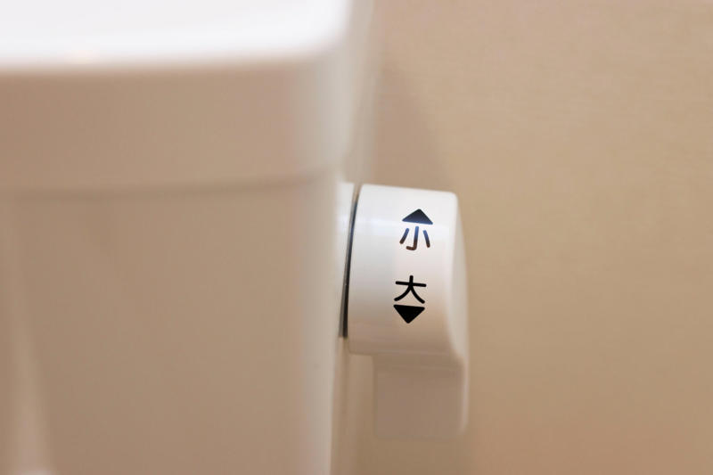 トイレの「大」と「小」はどう使い分ける？, 「大」は大便、「小」は小便が基本, 紙を使ったときは、量と機種で考え方が変わる, 迷ったときに「大」を選んだ方がいい, 便や紙を「小」で流すと、なぜ詰まりやすい？, しっかり流すには、それに見合う水の量がいる, 便器から消えても、配管の途中で止まることがある, 紙は「溶ける」より「ほぐれる」に近い, 「大」と「小」で水の量と水道代はどれくらい変わる？, 1回で変わる水量の目安, 4人家族なら年間でどれくらい差が出る？, 古いトイレと新しいトイレでは差がもっと大きい, 自動洗浄のトイレは、どうやって「大」「小」を決める？, 座っていた時間で判定する機種がある, 自動でも「手動で大」にした方がいい場面がある, 自動任せにしすぎないための注意点, やってはいけないトイレの節約法, タンクにペットボトルを入れる, 止水栓を絞って水量を調整する, 厚手の紙や流せるシートをまとめて流す, 迷ったら「大」を選ぶ方が、結局ムダがない