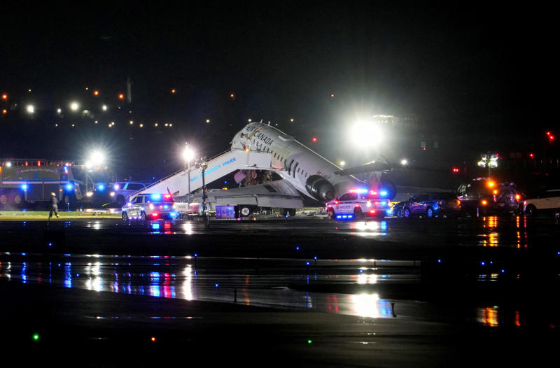 Emergency crews work around an Air Canada Express jet that had collided with a ground vehicle at LaGuardia Airport in Queens, New York, March 23, 2026.
