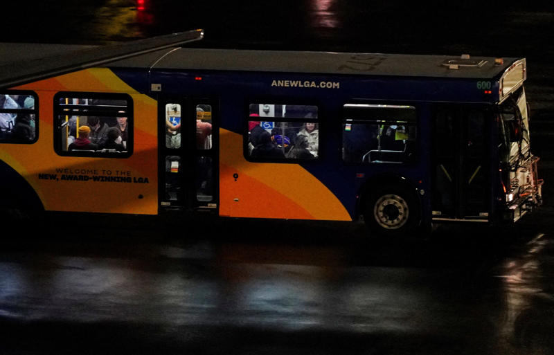 A bus transports plane crash survivors after an Air Canada Express jet collided with a ground vehicle at LaGuardia Airport, March 23, 2026.