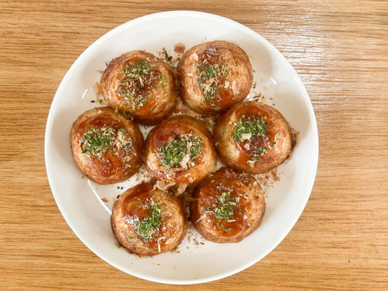 並べて比較！ 丸型の「業スー」と山型の「ロピア」, 【業務スーパー】1個あたり約16.4円！ とろとろ食感の「リアル屋台系」, 生地がとろけ出す！ タコの存在感も抜群, 【ロピア】1個あたり約13.4円！ 香ばしさがクセになる「揚げ焼き系」, お出汁が効いてフワフワ！ カリッとした香ばしさが魅力, 【結論】屋台派は「業スー」、揚げたこ焼き派は「ロピア」！