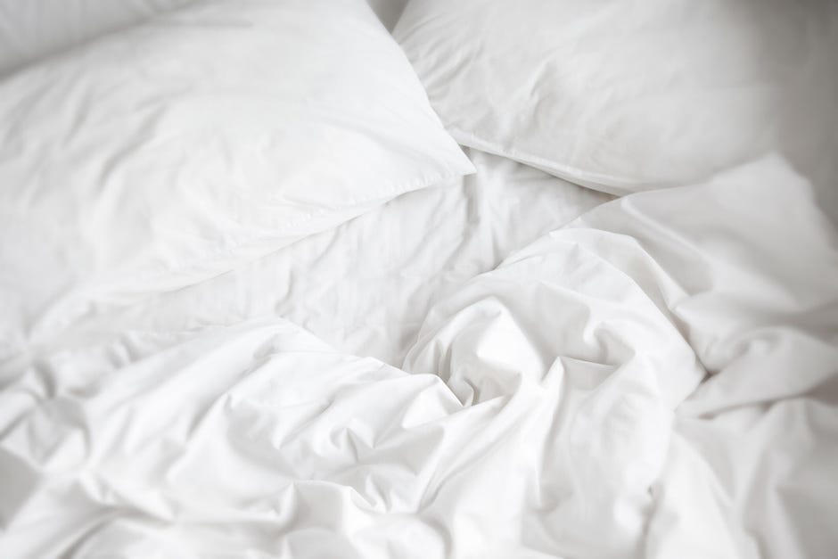 1. Freeze your sheets and pillowcases, 2. Also throw your socks in the freezer, 3. Use house fans to make your own AC, 4. Use a wet towel layer, 6. Use cooling bed linens, 7. Consider a cooling mattress, 8. Block out the daytime sun and heat, 9. Sleep on the first level of your home, 10. Drink ice water before bed