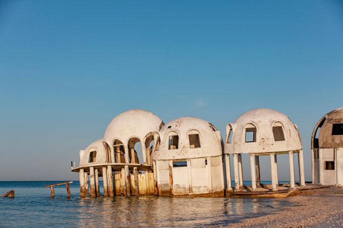 Abandoned places that will give you the chills, Old City Hall Station, 1984 Olympic venues, Ta Prohm Temple, The Pines, Michigan Central Station, Bombay Beach, Hashima Island, Old Cahawba, Castle Frankenstein, Iron Goat Trail, SS Ayrfield, Bedrock City, Gwynned slate quarries, The Astrodome, Seattle Underground, Tillamook Lighthouse, 29 Buffalo Central Terminal, Rhyolite, Presidio Modelo, Cementerio de Trenes, Kolmanskop, Old stairway at Bankhead, Gereja Ayam, St. Kilda, Canfranc railway station, Poveglia, Cape Romano dome house