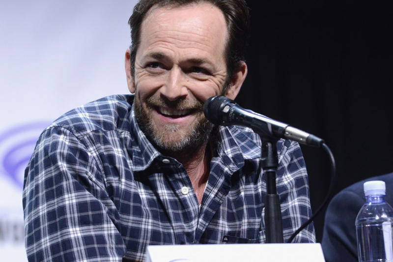 Gone too soon, Luke got lucky when he landed a role on 'Beverly Hills, 90210', Dylan McKay the bad boy everyone loved, Luke was one of THE 90s heartthrobs, Luke took a break from '95-'98 to work on movies, But Luke couldn't resist returning to '90210', Luke marries and becomes a father, Luke struggled to find the same degree of success after '90210', Luke landed starring roles but the shows didn't last long..., Broadway and theatre in London, Luke was even in a Swedish comedy in the mid-2000s, A health scare in 2015, Perry began advocacy work, Luke found his place again on 'Riverdale', Luke Perry wanted to do a reboot of '90210', A reboot in the works??, Fans were thrilled, ...but Luke had a conflict due to his contract with 'Riverdale', Tragedy strikes, Luke was 52 when he passed away, Perry's final role was in a Tarantino film, Luke was secretly engaged at the time of his death, They were said to be "smitten", An icon that is dearly missed
