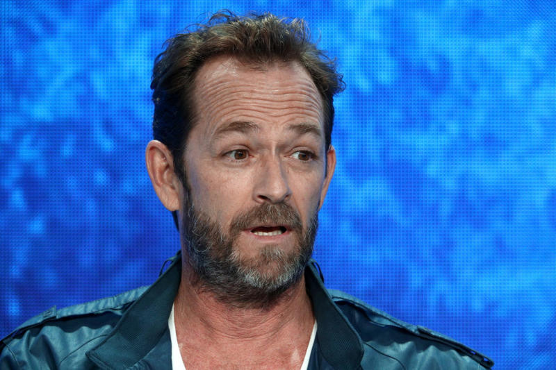 Gone too soon, Luke got lucky when he landed a role on 'Beverly Hills, 90210', Dylan McKay the bad boy everyone loved, Luke was one of THE 90s heartthrobs, Luke took a break from '95-'98 to work on movies, But Luke couldn't resist returning to '90210', Luke marries and becomes a father, Luke struggled to find the same degree of success after '90210', Luke landed starring roles but the shows didn't last long..., Broadway and theatre in London, Luke was even in a Swedish comedy in the mid-2000s, A health scare in 2015, Perry began advocacy work, Luke found his place again on 'Riverdale', Luke Perry wanted to do a reboot of '90210', A reboot in the works??, Fans were thrilled, ...but Luke had a conflict due to his contract with 'Riverdale', Tragedy strikes, Luke was 52 when he passed away, Perry's final role was in a Tarantino film, Luke was secretly engaged at the time of his death, They were said to be "smitten", An icon that is dearly missed