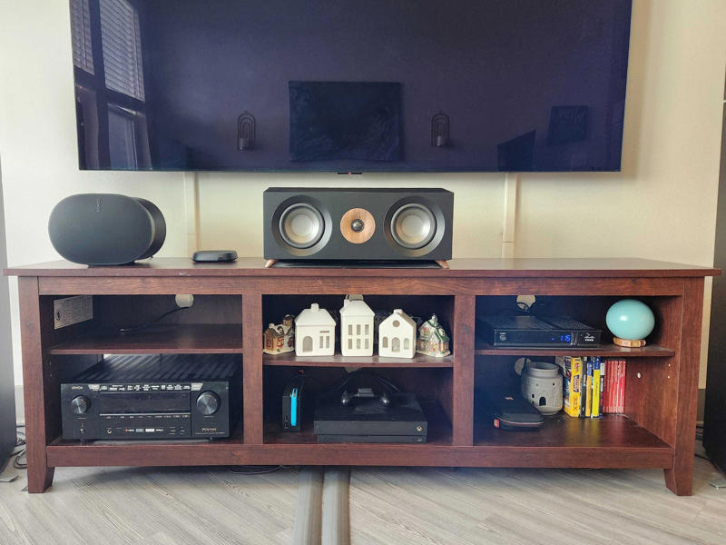 An extra-large OLED 4K TV, A wide TV console with big storage cubbies, A mount to keep my display on the wall, A surround sound system, A beefy A/V receiver to power and process my speakers, Sturdy stands to keep my rear speakers in place, Lots of HDMI cables to connect everything, Speaker wires with banana plugs for a hassle-free setup, A reliable Roku to stream my favorite apps, A gaming console to play the latest titles