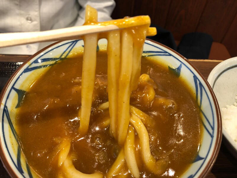 丸亀製麺の「カレーうどん」はたっぷりカレーが特徴, 丸亀製麺の「カレーうどん」は甘めのカレー。うどんに絡んでおいしい！ 口コミも紹介, 丸亀製麺の「カレーうどん」の値段・価格・コスパ, 丸亀製麺の「カレーうどん」の原材料・内容量・アレルギー情報, 丸亀製麺の「カレーうどん」のカロリー・栄養成分表示, 1.白ごはんでカレーライス, 2.人気No.1の天ぷら「かしわ天」を足す, 3.野菜かき揚げを足す, 4.半熟玉子天でカレーをまろやかに, 丸亀製麺の「カレーうどん」はテイクアウト（持ち帰り）できる？, 丸亀製麺の「トマたまカレーうどん」や「熱盛カレーうどん弁当」はいつまで？ 販売終了した？