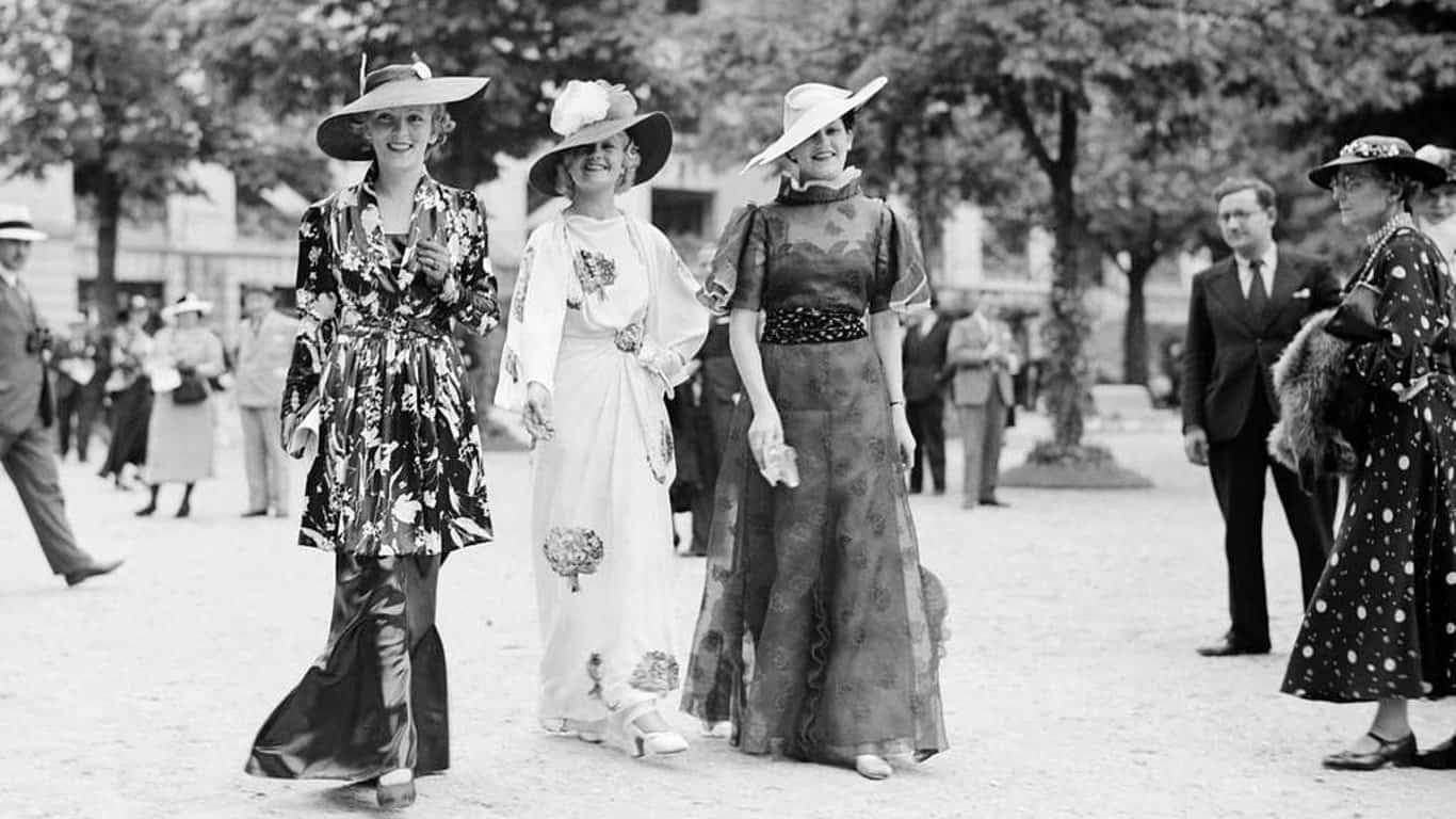 4. Three women modeling dresses by Marcelle Landowska 1. Three models with hats by Hélène Sorbier, 2. People celebrating New Year’s Eve at El Morocco in New York City, 3. Ernest Hemingway and Marlene Dietrich, 4. Three women modeling dresses by Marcelle Landowska, 5. Lady smiling for a portrait, 6. Family of four listening to the radio, 7. German film director Fritz Lang, 9. Stepping out for a spring fashion parade in Brisbane, Australia, 10. Jean Harlow with Marcel Waves, 11. Conductors Serge Koussevitsky (left) and Sir Thomas Beecham, 12. Models with an audience in Paris, 13. American cartoonist and fashion designer Gladys Parker, 14. Three women with hats in Paris, 15. Golfer Bobby Jones (right) with the Walker Cup in Sandwich, England, 16. Models posing for a fashion shoot, 17. Modeling dresses by Hélène Sorbier in Paris, 18. German industrialist and arms manufacturer Gustav Krupp von Bohlen und Halbach (second from right) with his extended family, 19. A model in Paris, 20. Louisiana governor and senator Huey Long at a radio broadcast, 21. Brazilian politician Getúlio Vargas, 22. A model at the House of Paquin in Paris, 23. Two models in suits in Paris, 24. Austrian doctor and psychotherapist Alfred Adler, 25. Boxer Jack Dempsey, 26. British politician James Thomas (center) and friends, 27. Posing outside a cat show at the Salle Wagram, Paris, 28. Miss France, 29. Attorney Clarence Darrow (right), 30. Model De Decker with hat, 31. Actresses Laurette Taylor (left) and Ethel Barrymore, 32. Model De Decker with another hat, 33. Two models with hats in Paris, 34. Model Eliane Richer with hat, 35. Austrian-born actor and director Erich Von Stroheim, 36. Model Hélène Sorbier with hat, 37. Douglas Fairbanks Jr. (left), Charlie Chaplin, and Mary Pickford, 38. Fashion models, 39. Model in long dress with hat, 40. Models in a Red Bug Electric Roadster car at the Edison Electrical Exposition in New York, 41. Model with a hat, 42. Gary Cooper (right) and a location caterer on the set of “The Spoilers”, 43. A reception for golfer Bobby Jones after his British Open victory, 44. Model in a dress, 45. British photographer and costume designer Cecil Beaton, 46. Business mogul and multimillionaire John D. Rockefeller, 47. Five college girls jumping in winter clothes, 48. Model Hélène Sorbier with hat, 49. Model in a summer dress with hat, 50. Businessman and philanthropist Simon Guggenheim, 51. Diplomats from Czechoslovakia, Romania, and Yugoslavia at a Little Entente conference in Belgrade, 52. Model with a hat in Paris, 53. Woman standing outside