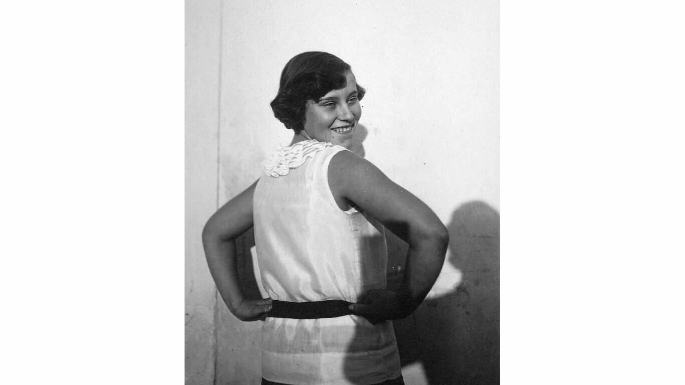 5. Lady smiling for a portrait 1. Three models with hats by Hélène Sorbier, 2. People celebrating New Year’s Eve at El Morocco in New York City, 3. Ernest Hemingway and Marlene Dietrich, 4. Three women modeling dresses by Marcelle Landowska, 5. Lady smiling for a portrait, 6. Family of four listening to the radio, 7. German film director Fritz Lang, 9. Stepping out for a spring fashion parade in Brisbane, Australia, 10. Jean Harlow with Marcel Waves, 11. Conductors Serge Koussevitsky (left) and Sir Thomas Beecham, 12. Models with an audience in Paris, 13. American cartoonist and fashion designer Gladys Parker, 14. Three women with hats in Paris, 15. Golfer Bobby Jones (right) with the Walker Cup in Sandwich, England, 16. Models posing for a fashion shoot, 17. Modeling dresses by Hélène Sorbier in Paris, 18. German industrialist and arms manufacturer Gustav Krupp von Bohlen und Halbach (second from right) with his extended family, 19. A model in Paris, 20. Louisiana governor and senator Huey Long at a radio broadcast, 21. Brazilian politician Getúlio Vargas, 22. A model at the House of Paquin in Paris, 23. Two models in suits in Paris, 24. Austrian doctor and psychotherapist Alfred Adler, 25. Boxer Jack Dempsey, 26. British politician James Thomas (center) and friends, 27. Posing outside a cat show at the Salle Wagram, Paris, 28. Miss France, 29. Attorney Clarence Darrow (right), 30. Model De Decker with hat, 31. Actresses Laurette Taylor (left) and Ethel Barrymore, 32. Model De Decker with another hat, 33. Two models with hats in Paris, 34. Model Eliane Richer with hat, 35. Austrian-born actor and director Erich Von Stroheim, 36. Model Hélène Sorbier with hat, 37. Douglas Fairbanks Jr. (left), Charlie Chaplin, and Mary Pickford, 38. Fashion models, 39. Model in long dress with hat, 40. Models in a Red Bug Electric Roadster car at the Edison Electrical Exposition in New York, 41. Model with a hat, 42. Gary Cooper (right) and a location caterer on the set of “The Spoilers”, 43. A reception for golfer Bobby Jones after his British Open victory, 44. Model in a dress, 45. British photographer and costume designer Cecil Beaton, 46. Business mogul and multimillionaire John D. Rockefeller, 47. Five college girls jumping in winter clothes, 48. Model Hélène Sorbier with hat, 49. Model in a summer dress with hat, 50. Businessman and philanthropist Simon Guggenheim, 51. Diplomats from Czechoslovakia, Romania, and Yugoslavia at a Little Entente conference in Belgrade, 52. Model with a hat in Paris, 53. Woman standing outside