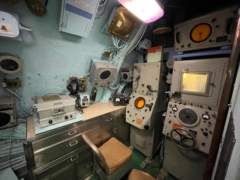 The sonar room also aided Growler's navigation. In the navigation compartment, crew members plotted courses and tracked Growler's position., The missile checkout and guidance center was once a top-secret area., Officers had access to their own shower., Officers used the wardroom to eat, socialize, and hold meetings., Yeomen handled clerical and administrative work aboard the USS Growler's tiny office., Here, the commanding officer would give orders to the crew., The sonar room also aided Growler's navigation., Crew members communicated with other ships in the radio room., Meals were prepared in the galley., In the scullery, Growler crew members washed dishes and compacted trash., The crew's mess was the only common space on the USS Growler., Growler's largest sleeping area contained 46 bunks., The crew's washroom featured two showers., Growler's three diesel engines were located in the engine room.