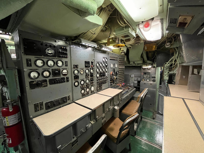 The missile checkout and guidance center was once a top-secret area. In the navigation compartment, crew members plotted courses and tracked Growler's position., The missile checkout and guidance center was once a top-secret area., Officers had access to their own shower., Officers used the wardroom to eat, socialize, and hold meetings., Yeomen handled clerical and administrative work aboard the USS Growler's tiny office., Here, the commanding officer would give orders to the crew., The sonar room also aided Growler's navigation., Crew members communicated with other ships in the radio room., Meals were prepared in the galley., In the scullery, Growler crew members washed dishes and compacted trash., The crew's mess was the only common space on the USS Growler., Growler's largest sleeping area contained 46 bunks., The crew's washroom featured two showers., Growler's three diesel engines were located in the engine room.