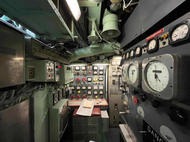 Sailors controlled Growler's speed in the maneuvering room, with officers communicating orders from the control room. In the navigation compartment, crew members plotted courses and tracked Growler's position., The missile checkout and guidance center was once a top-secret area., Officers had access to their own shower., Officers used the wardroom to eat, socialize, and hold meetings., Yeomen handled clerical and administrative work aboard the USS Growler's tiny office., Here, the commanding officer would give orders to the crew., The sonar room also aided Growler's navigation., Crew members communicated with other ships in the radio room., Meals were prepared in the galley., In the scullery, Growler crew members washed dishes and compacted trash., The crew's mess was the only common space on the USS Growler., Growler's largest sleeping area contained 46 bunks., The crew's washroom featured two showers., Growler's three diesel engines were located in the engine room.